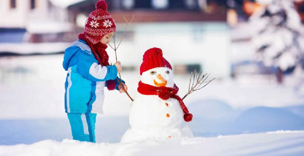Child outside building a snowman